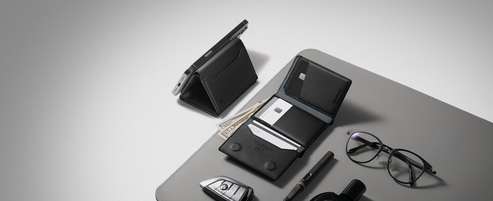 Image showing the Spigen Valentinus S card holder on desk mat with glasses , pen and car remote next to it