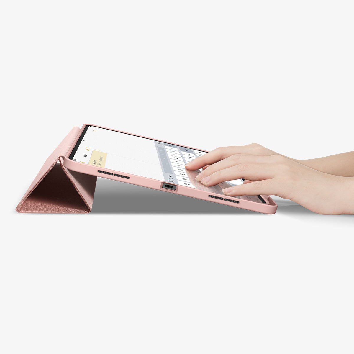 ACS07011 - iPad Pro 12.9-inch Case Urban Fit in Rose Gold showing the partial front with a hand typing on the device with a folded front cover propped up as a stand