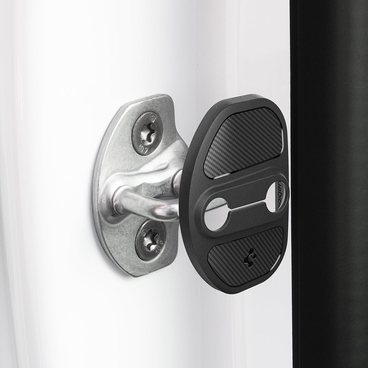ACP07123 - Tesla Model Y & 3 Door Lock Cover TO320 in Black showing the door lock cover hovering in front of the door striker hook
