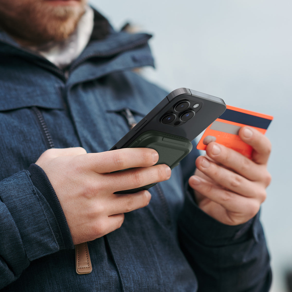 AFA08528 - MagSafe Card Holder Lock Fit (MagFit) in Military Green showing the card holder attached to back of a device in someone's hand