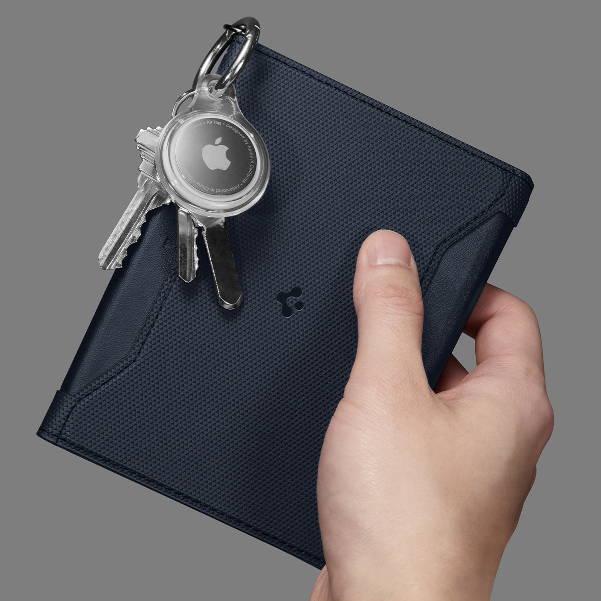 AFA08721 - Passport Holder in Navy Blue showing the front with carabiner attached for airtag and keys