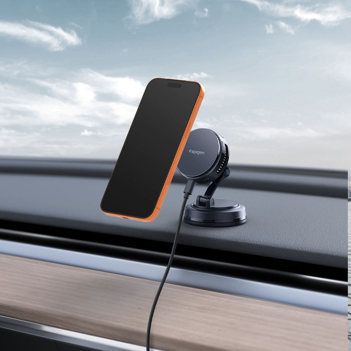 ACP11399 - Peltier Dashboard Charging Mount with Cable | PLT100 (Mag Fit) showing an orange iPhone attached to the PLT100 mount on a car dashboard, cable connected.