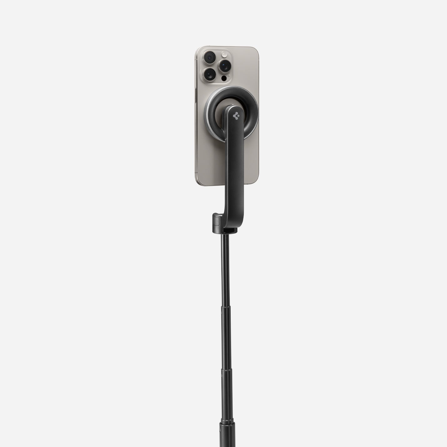 AMP07659 - Tripod Selfie Stick (Mag Fit) | S580W in Black showing the back of an iPhone attached magnetically to the S580W selfie stick via the MagFit mount, with the stick fully extended against a light gray background.