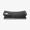 ACS09794 - Spigen Rugged Armor Galaxy A57 5G case in Matte Black lifting away from phone, showing flexible TPU construction
