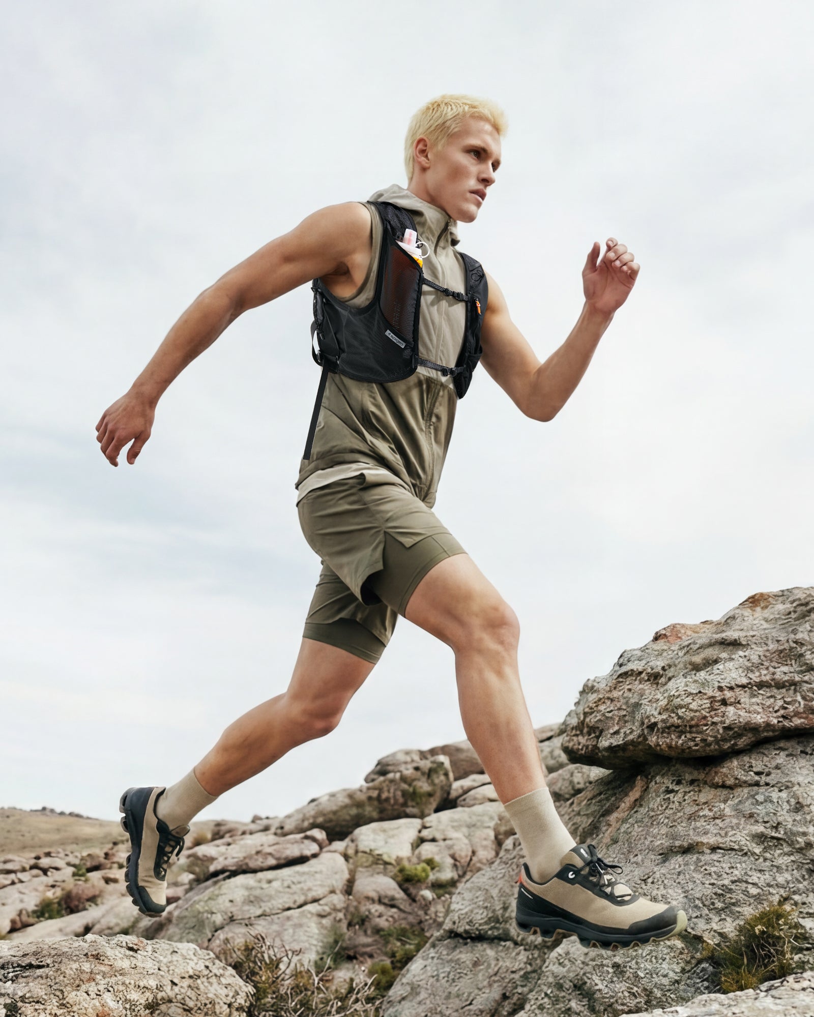 AMP10225 - Dynamic Shield™ Running Vest | A721 L-XL in Black worn by a runner climbing rocky terrain outdoors.