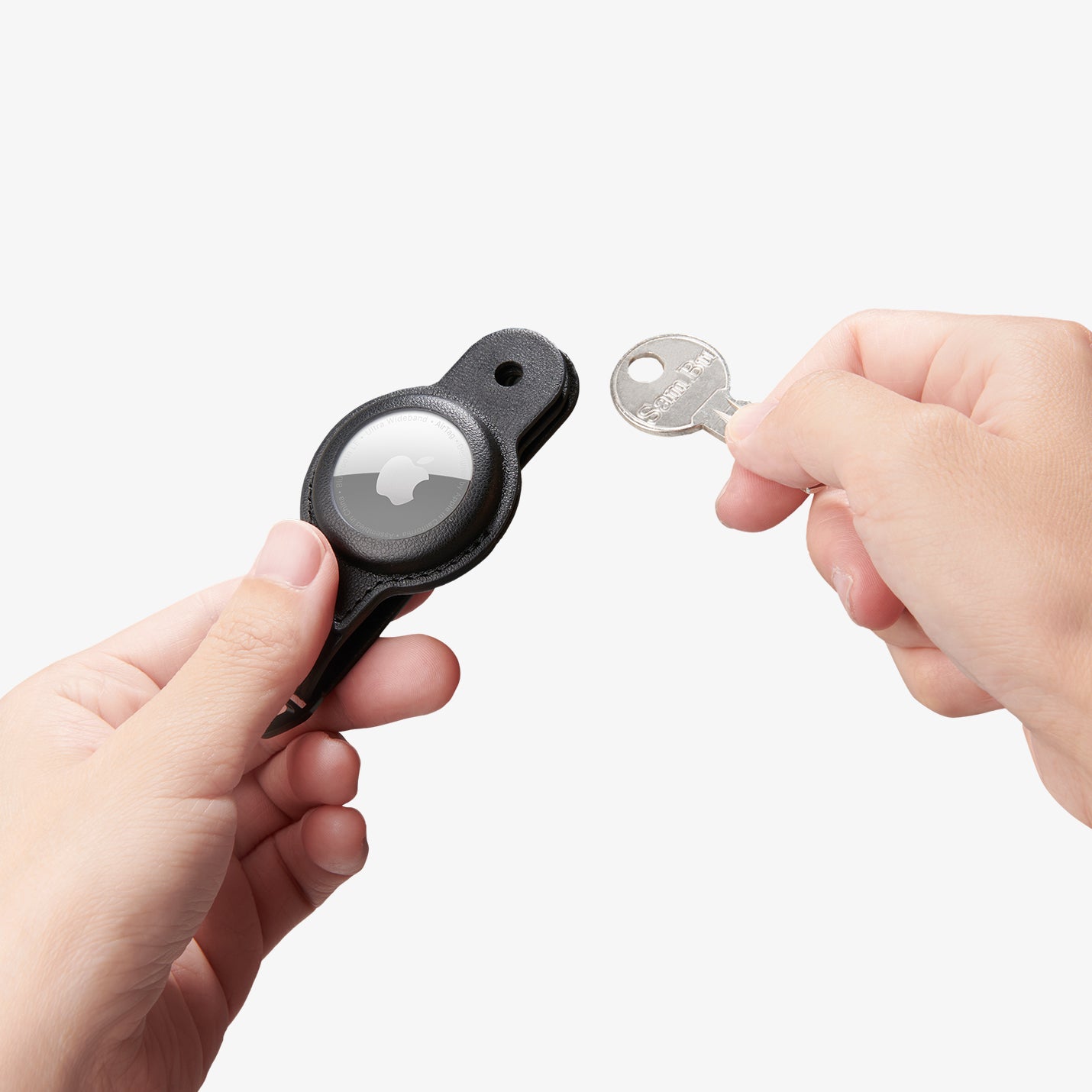 AHP09660 - Apple AirTag Valentinus Pro in Black showing a person holding the airtag case with the left hand and a key on the right hand