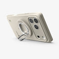 AMP11738 - Spigen Classic LS MagSafe ring attached to the back of a phone, propped up as a stand next to the camera