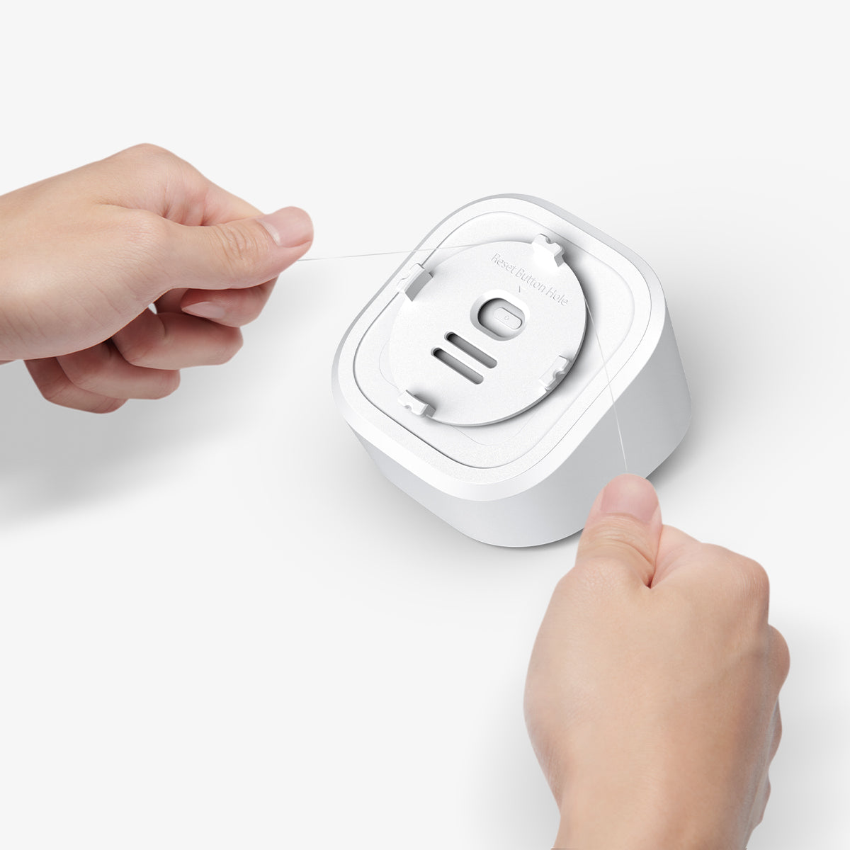 AMP09409 - Eero 6 Mount | ER110 in White showing the back, a person using a sturdy string to remove the bracket