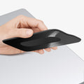 APP11228 - SSD/HDD Holder | LD221 in Black showing hand pressing flat against MacBook lid with adhesive backing partially removed for placement