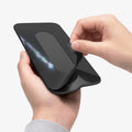 APP11228 - SSD/HDD Holder | LD221 in Black showing hands peeling adhesive backing with flexible fabric pouch stretching open for SSD insertion