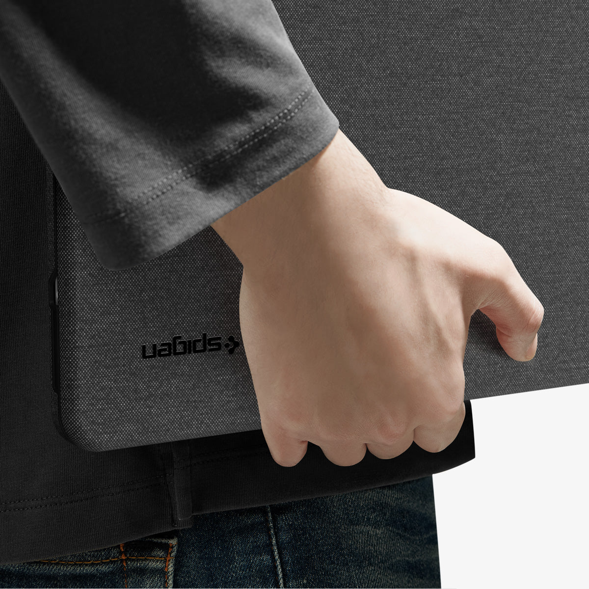 ACS11541 - MacBook Neo 13-inch Urban Fit in Black showing close up of case tucked under arm, logo detail visible