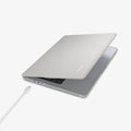 ACS10977 - MacBook Pro 16-inch in Heather Gray showing the top and side with laptop slightly open and charging cable next to port