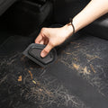 ACP11829 - Hand using the Spigen scraper to clear pine needles and debris from a car floor mat