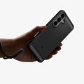 ACS11639 - Galaxy S26 FE Rugged Armor showing Rugged Armor case held with an attached wrist strap for secure everyday carry