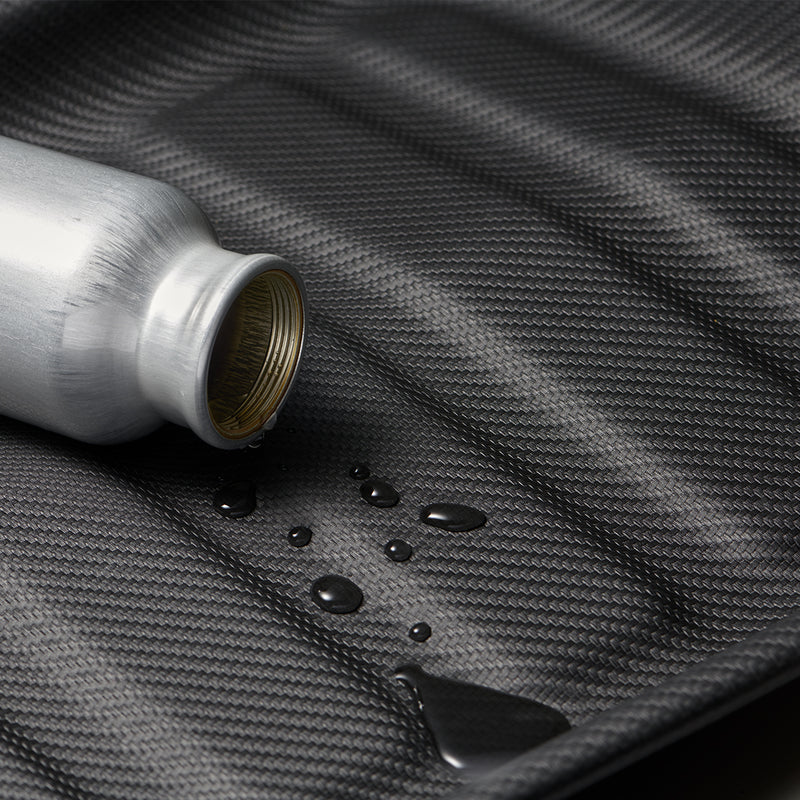 ACP06528 - Tesla Model Y Rear Trunk Storage Mat TL00-Y in Black showing the mat spilled by a water from a bottle without the mat absorbing the liquid
