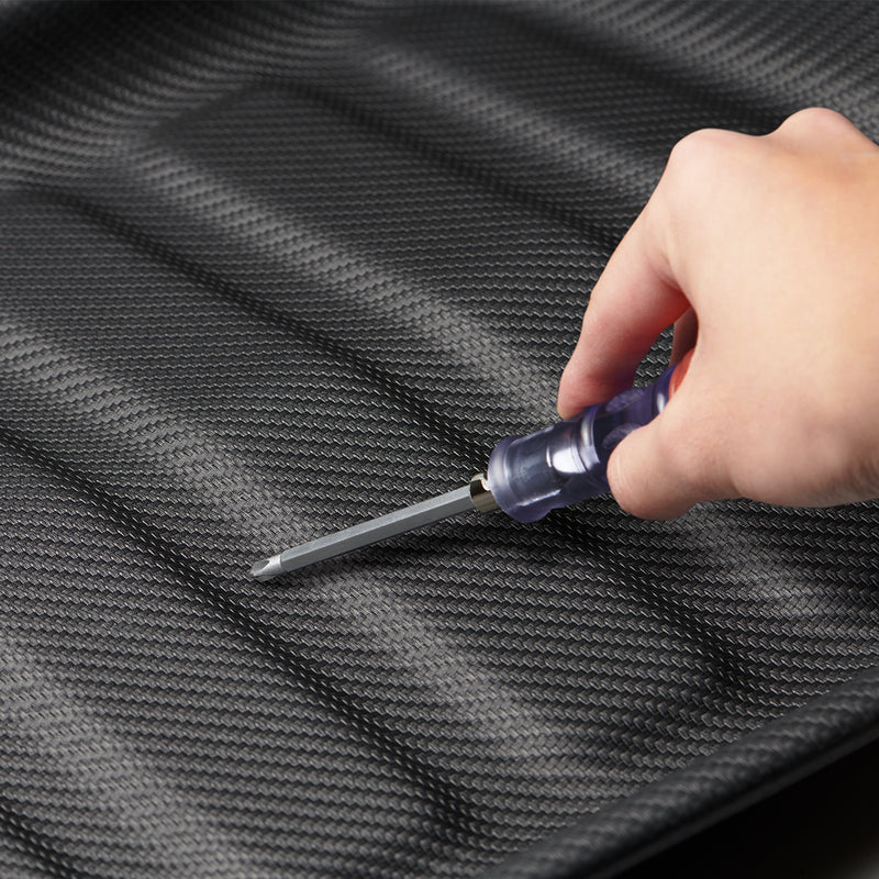 ACP06528 - Tesla Model Y Rear Trunk Storage Mat TL00-Y in Black showing a hand holding a tool testing the durability of the mat