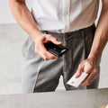 AFA09442 - MagSafe Card Holder Valentinus Pro | 3 Cards in Black showing a person holing the wallet on the other hand and card on the other hand
