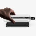 AGL11485 - Pixel 11 Pro XL GLAS.tR EZ Fit Pro hand lowering the installation tray onto the phone with the dust removal tab extended for quick and precise screen protector installation.