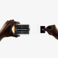 AGL11759 - Galaxy Z Fold 8 GLAS.tR EZ Fit Pro showing two hands pulling the black tab from the opposite side of the installation tray during application.