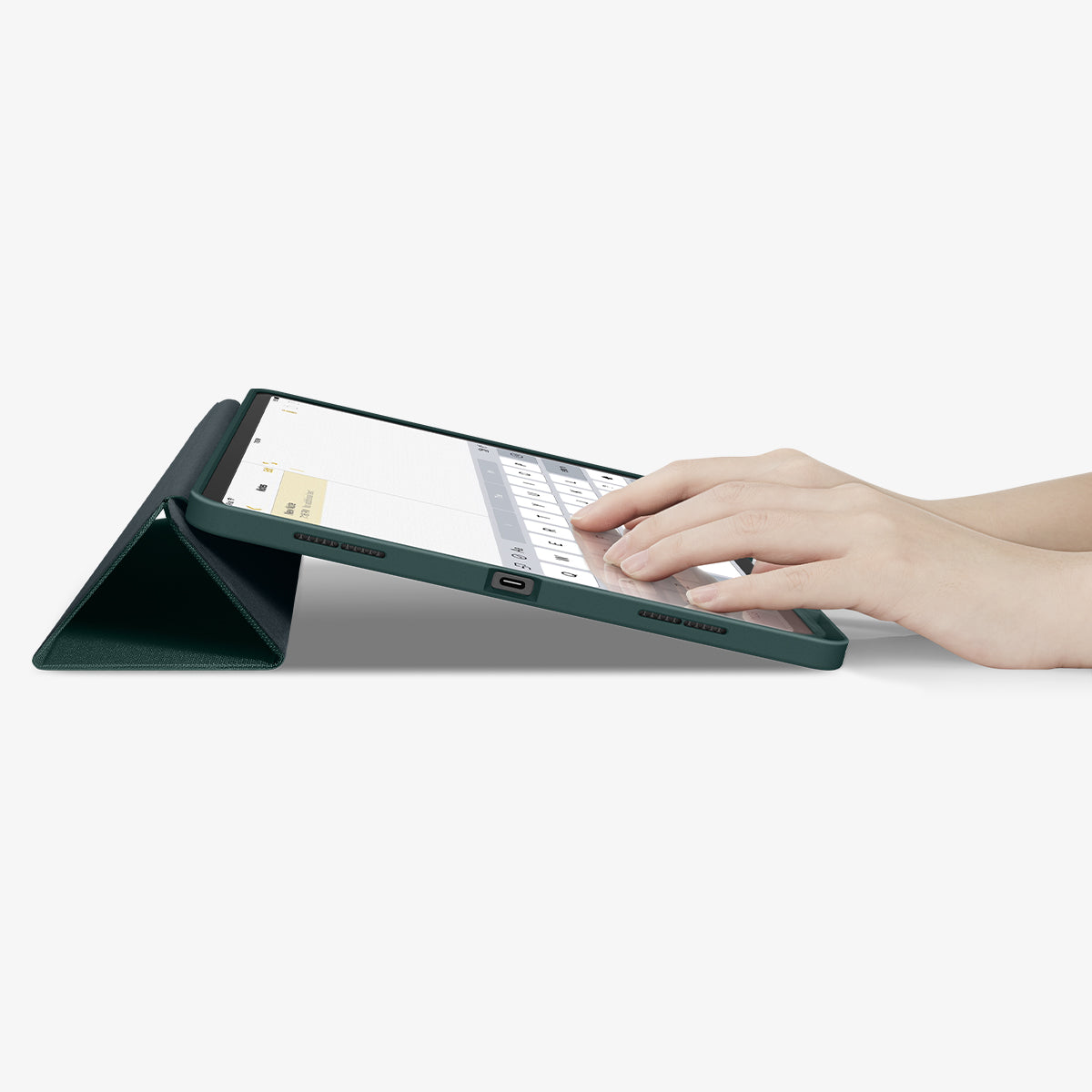 ACS07672 - iPad Air 12.9-inch Case Urban Fit in Midnight Green showing the partial front with a hand typing on the device with a folded front cover propped up as a stand