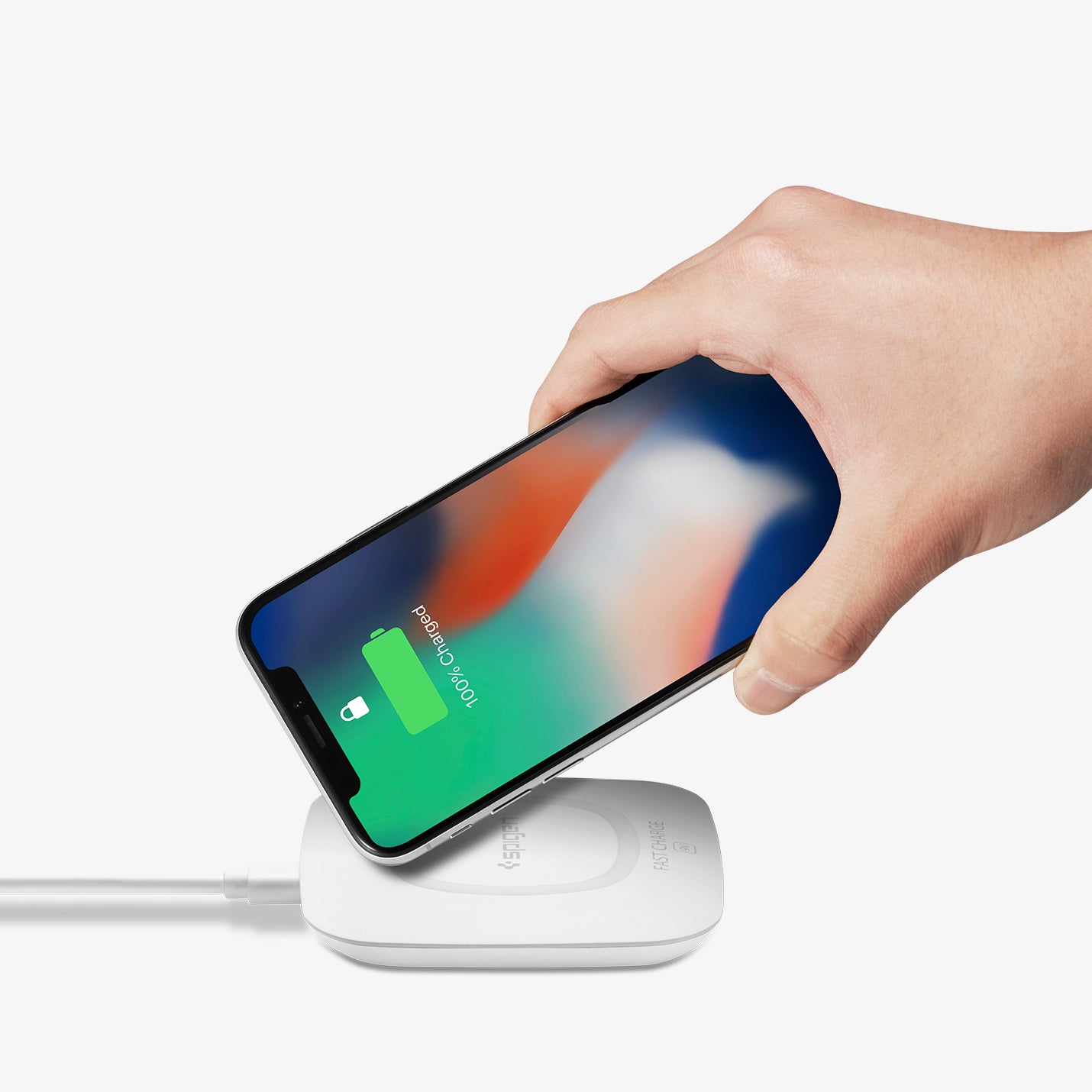000CH22588 - Essential® 10W Wireless Charger F301W in White showing the hand holding the device tapping the upper left corner of the device to a wireless charger