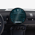 AGL09280 - Spigen display protector installed on a MINI Cooper's round dashboard screen, viewed from the driver's seat with the steering wheel in frame