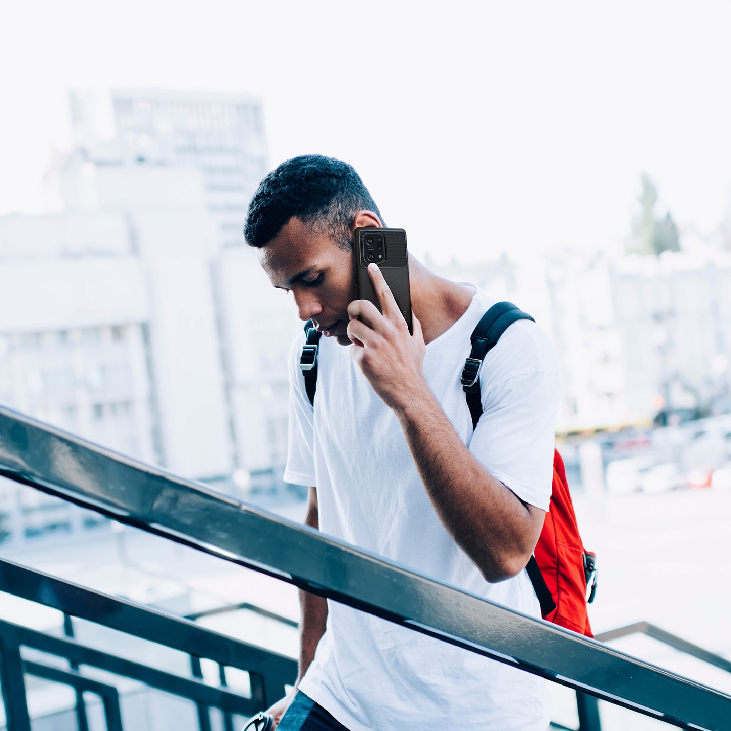 ACS04452 - OPPO Find Series Case Rugged Armor in black showing a man walking up the stairs while talking on the phone