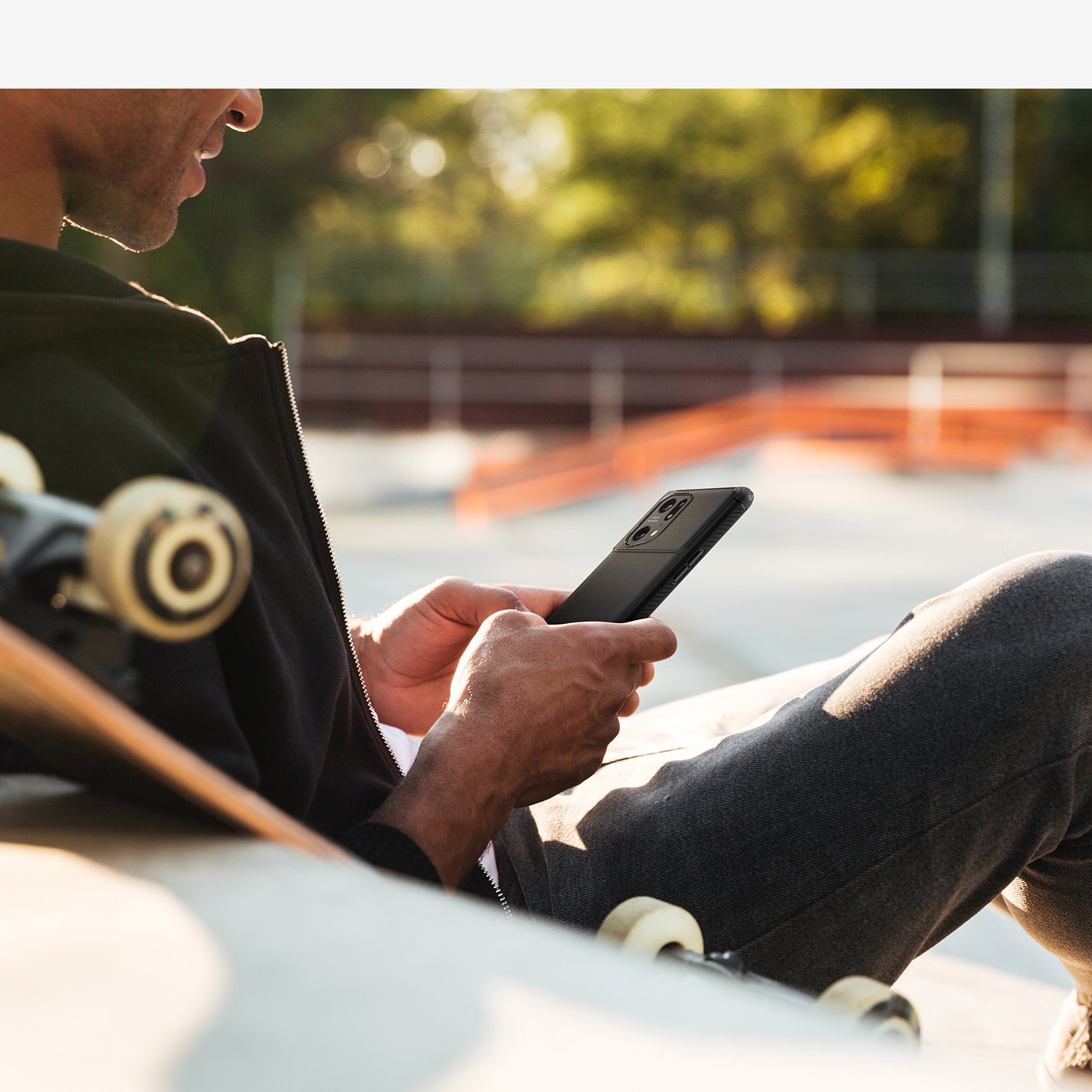 ACS04451 - OPPO Find Series Case Rugged Armor in black showing a man sitting at a skatepark with device in hand