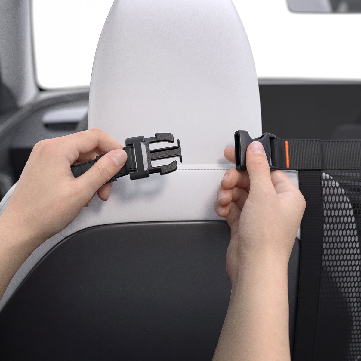 ACP11156 - Pet Car Backseat Barrier | PS200 in Black showing hands clipping the adjustable strap buckle around a car seat headrest to secure the mesh barrier in place.