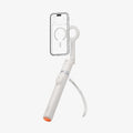 AMP11373 - Selfie Stick | S582W in Dune Beige showing a mounted smartphone on a magnetic holder with an extended handle, built-in tripod legs, and detachable remote control.