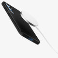 ACS08993 - Galaxy S25 Case Thin Fit (MagFit) in Black showing the back, partial side and bottom hovering in front of the magsafe charger