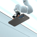 ACS08980 - Galaxy S25 Plus Case Liquid Air in Marble Gray showing the robotic arm holding the device in an elevated horizontal position, angled slightly upward. Showing the device back facing outward, revealing its camera module. The robotic arm is positioned above a clean, structured background with defined panels