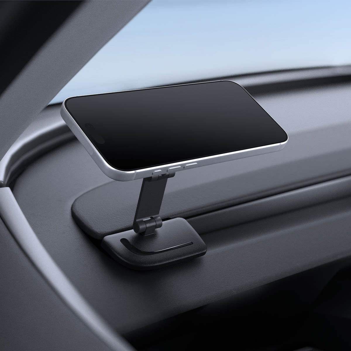 ACP11873 - Spigen magnetic phone mount folded flat, holding a phone at a low angle on a car dashboard corner near the window