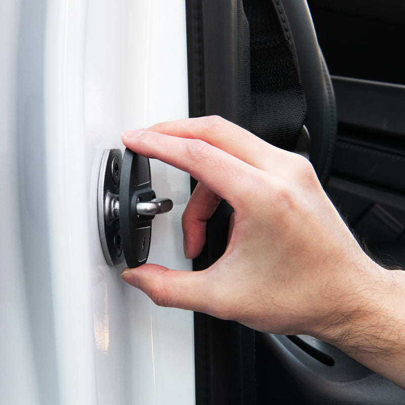 ACP07123 - Tesla Model Y & 3 Door Lock Cover TO320 in Black showing the hand of a man attaching the lock cover to the door striker hook