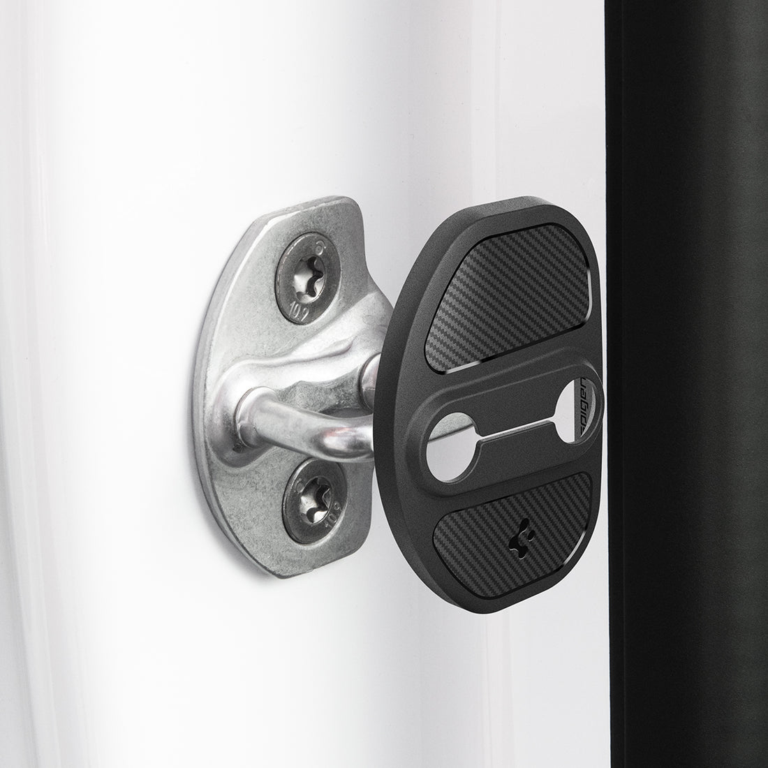 ACP07123 - Tesla Model Y & 3 Door Lock Cover TO320 in Black showing the door lock cover hovering in front of the door striker hook