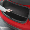 ACP11540 - Hand adjusting the black Spigen scuff plate protector fitted inside a Tesla trunk opening