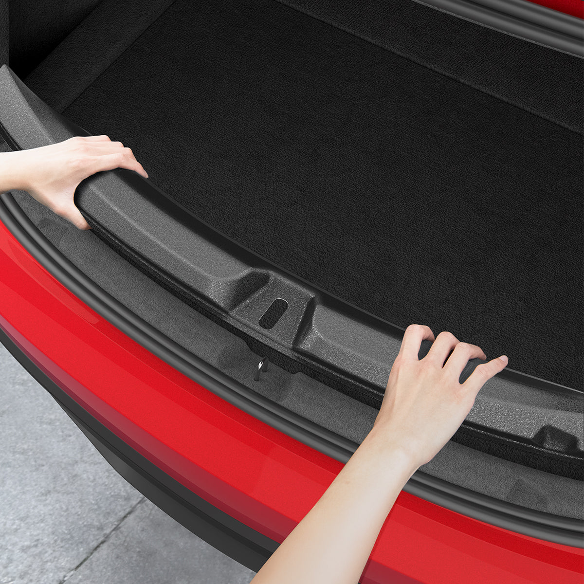 ACP11540 - Hands pressing the Spigen bumper protector into place along the edge of a Tesla trunk opening