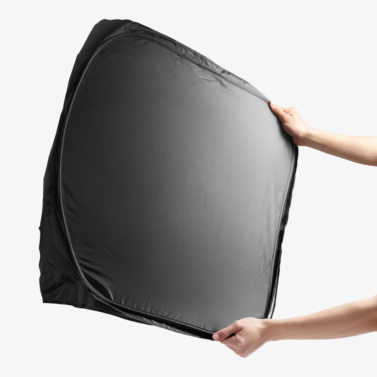 ACP11460 - Universal CryoShade UO260 M showing hands holding fully expanded black sunshade with reflective silver interior facing outward