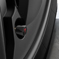 ACP11370 - Universal Tire Valve Stem Cap | VS100TS/R in silver installed on a wheel, featuring a faceted hexagonal design with a red Tesla logo accent.