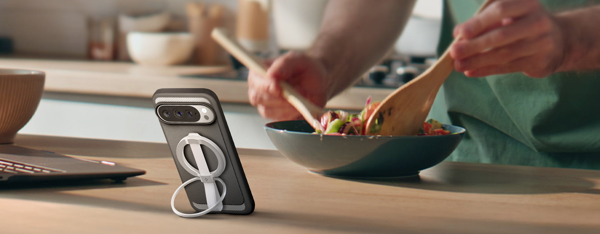Person mixing salad with phone propped up with MagFit Accessory