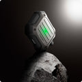 ASD01989 - Apple AirPods 3 Case Tough Armor in gunmetal showing the front and partial side balancing on top of the rock