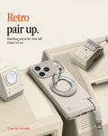 AMP11738 - Spigen Classic LS MagFit Ring on a phone displayed alongside matching cream retro-styled AirTag case and charger accessories designed to look like a vintage Macintosh set