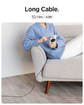 ACH04238 - ArcField™ Magnetic 7.5W Wireless Charger PF2101 (MagFit) in Black showing the Long Cable, 1.5m | 4.9ft. A woman sitting while holding a device attached to a wireless charger away from electric outlet