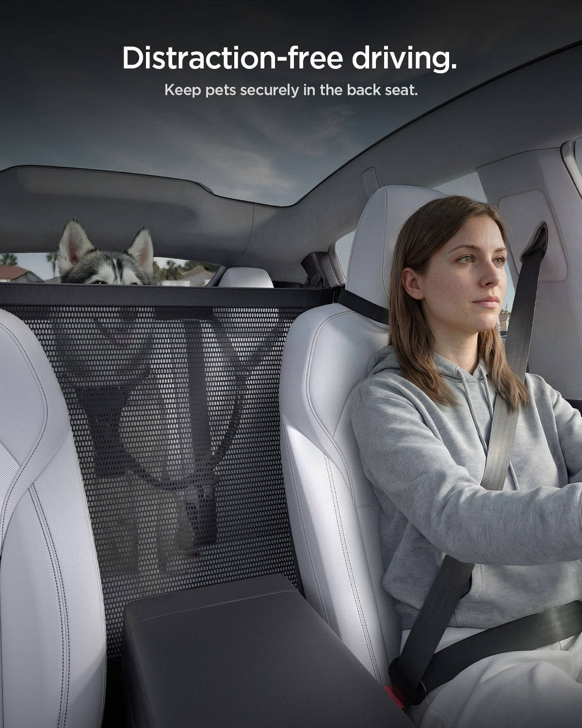 ACP11156 - Spigen Car Seat Pet Barrier installed between front and back seats showing driver separated from dog by mesh panel