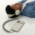 ACS10478 - iPhone 17 Pro Max Classic LS MagFit case connected to wired headphones while user relaxes listening to music on white surface