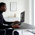 AMP11116 - Slim Fold Laptop Stand | LD201-S7 showing side view of person using MacBook laptop propped up on laptop stand and using mouse