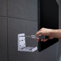 AMP06396 - Playstation 5 Console Mount | VG200 in white showing a person's hand holding a screw driver while installing the mount