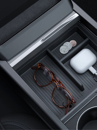 Showing the Tesla center console 3 section organizer with coins, airpod and glasses.