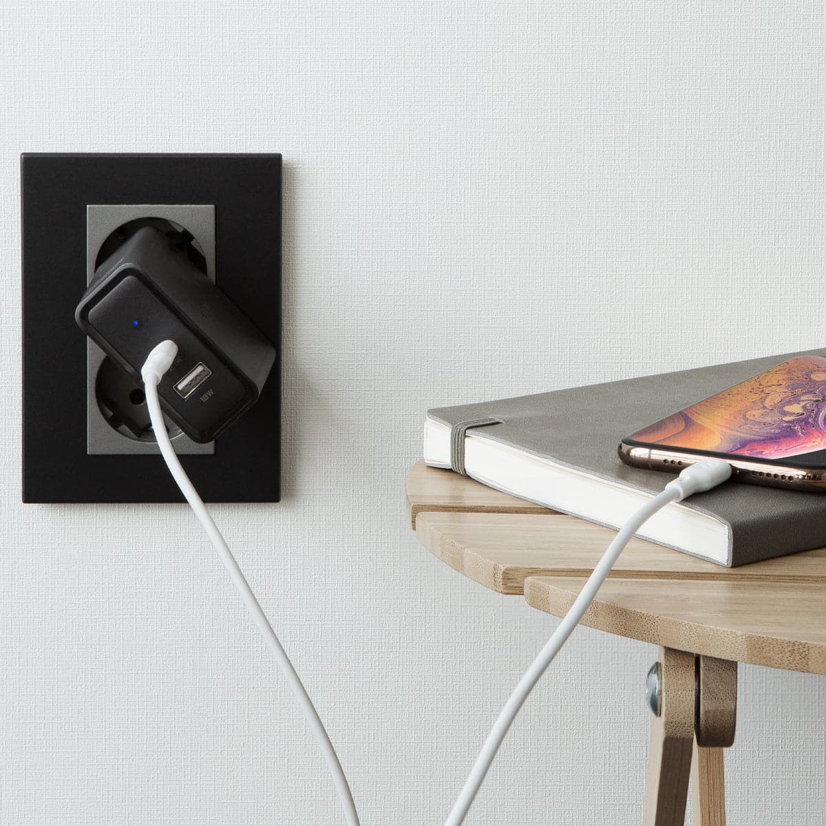 000CA25416 - DuraSync USB-C to Lightning Cable in white showing the cable connected to a wall charger and charging a phone