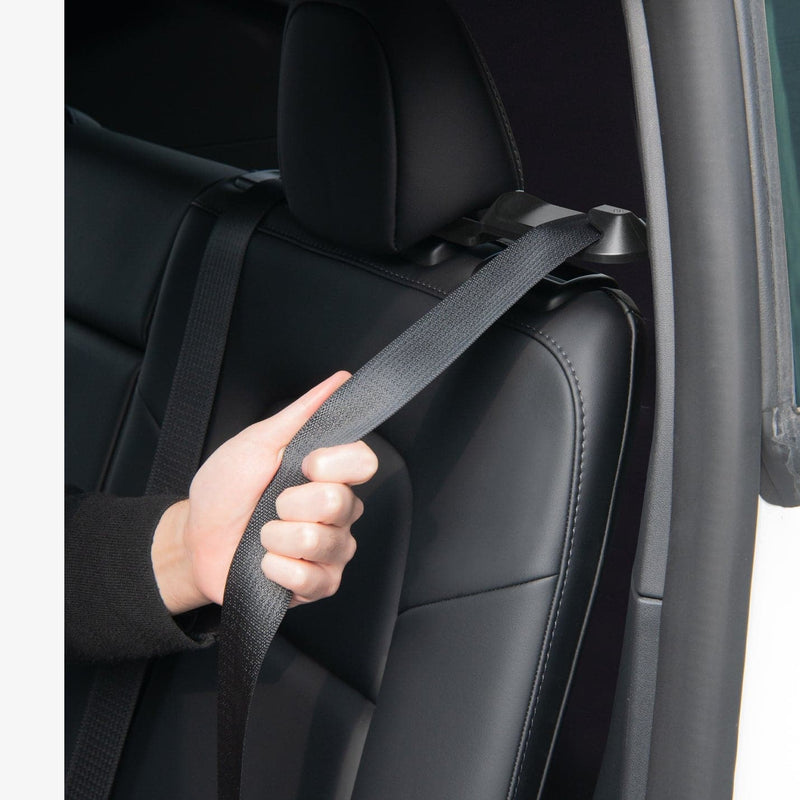 ACP06041 - Tesla Model Y Backseat Seatbelt Guide in black showing a hand pulling the seatbelt installed in guide inside of car